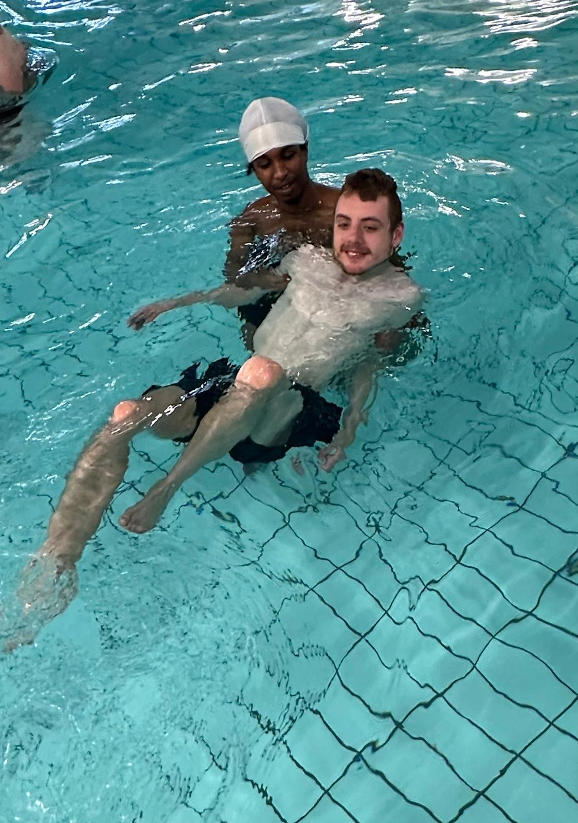 Support worker helping a participant in the pool